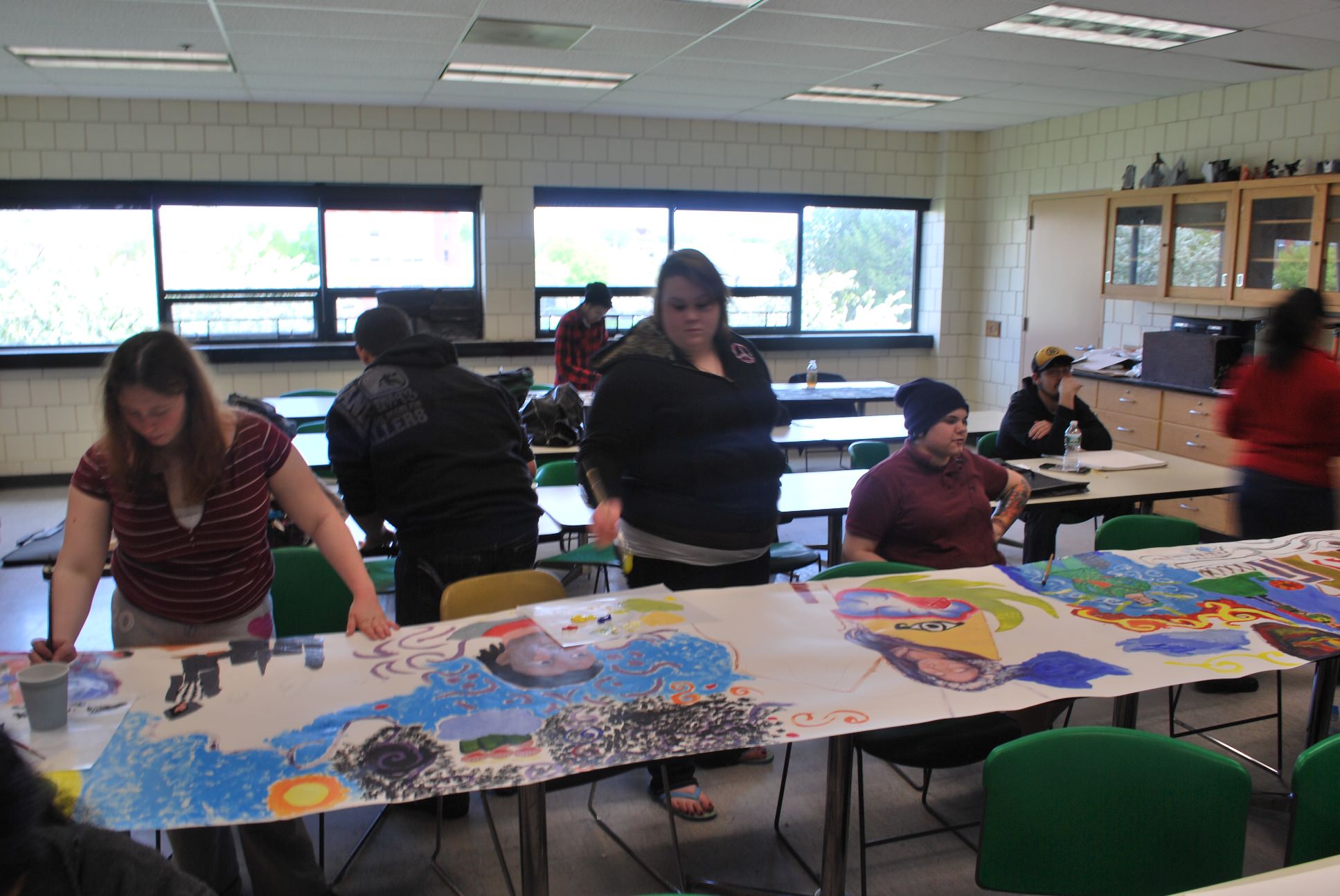 The class continues to color the mural